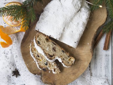 Geleneksel Noel şenlikli pasta tatlı festival dekorasyon - çam çırpı ve mandalina ile. Beyaz ahşap zemin üzerinde Noel stollen dilim. Üstten görünüm, kopya alanı