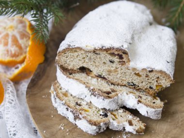 Geleneksel Avrupa Noel pasta, stollen, baharatlar ve kurutulmuş meyve kokulu ev pişmiş. Ahşap masanın üzerine dilimlenmiş xmas ile ağaç dalları ve süslemeleri, kopyalama alanı