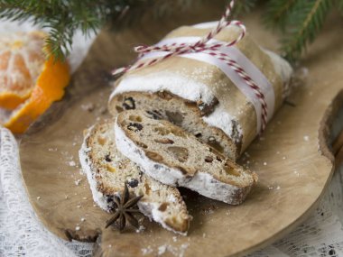 Geleneksel Avrupa Noel pasta, stollen, baharatlar ve kurutulmuş meyve kokulu ev pişmiş. Ahşap masanın üzerine dilimlenmiş xmas ile ağaç dalları ve süslemeleri, kopyalama alanı