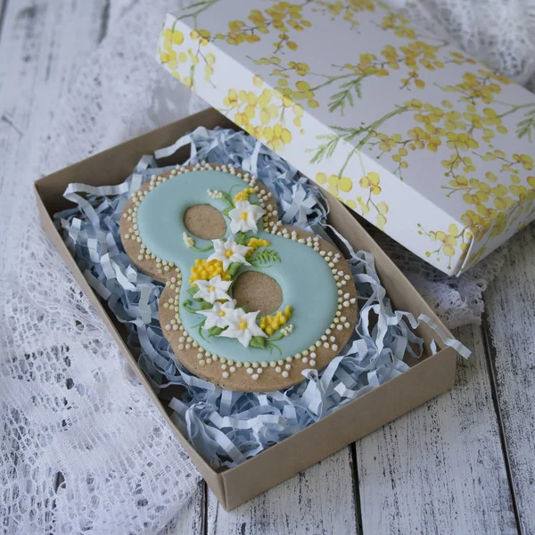 Beyaz ahşap arka plan üzerinde nergis ve mimoza ile sekiz numara şeklinde yapılmış mavi sır ile kaplı Cookie ile Kutu. Bisküvi Mart için 8.Hediye Uluslararası Kadınlar Günü.Festive kart. Üstte görüntü