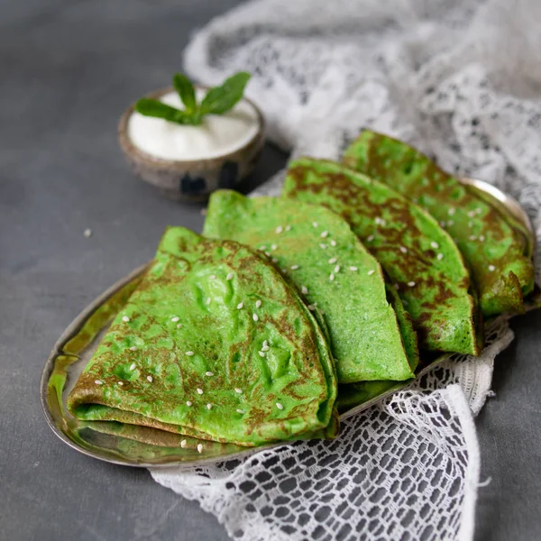 Grön mynta crepes med gräddfil och mynta blad på metallplattan på grå bakgrund med spets tyg. Närbild, kopiera utrymme, selektiv fokus, fyrkantig. — Stockfoto