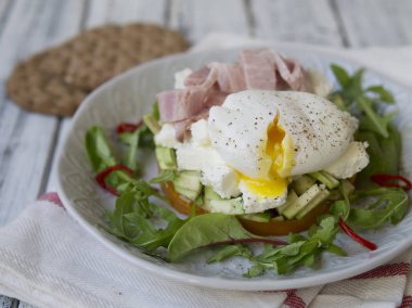 Sağlıklı Kahvaltı, tatlı patates, peynir, avokado, jambon, haşlanmış yumurta ve bütün tahıl ekmeği ile yeşillik. Diyet yemekleri. Kahvaltı ahşap masa lambası beyaz bir tabakta servis. Yakın çekim.