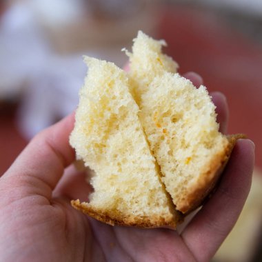 Yarı ev yapımı tatlı Paskalya ekmek fırıncı kadın elinde kesilmiş. Dilim Paskalya Ortodoks tatlı ekmek, kulich. Güzel dantel rulo kırıntıları. Seçici odak, kapatmak, alanı Kopyala