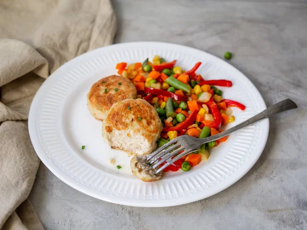 Куриные котлеты с приготовленными на пару овощами, куриные мясные шарики на белой тарелке. Хитрый обед, диетическая еда. Селективный фокус, крупным планом . — стоковое фото