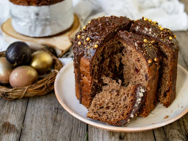 Incroyable gâteau de Pâques au chocolat avec des gouttes de chocolat et des cerises sèches sur un vieux fond en bois avec des œufs noirs et dorés. Une part de gâteau. Concept de Pâques. Mise au point sélective, gros plan . — Photo