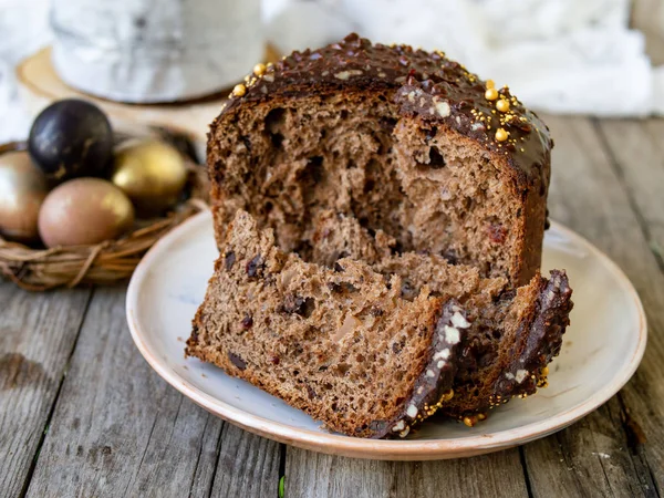 Incroyable gâteau de Pâques au chocolat avec des gouttes de chocolat et des cerises sèches sur un vieux fond en bois avec des œufs noirs et dorés. Une part de gâteau. Concept de Pâques. Mise au point sélective, gros plan . — Photo