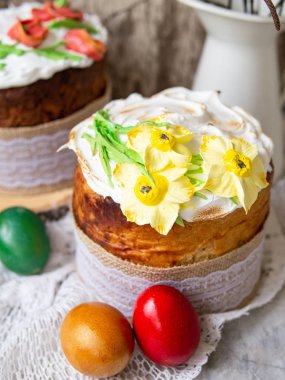 Paskalya pastası Kulich. Geleneksel Paskalya tatlı ekmek süslenmiş Meringue, dantel kumaş ve renkli yumurta ile ahşap gri arka plan üzerinde sarı nergis. Kopya alanı, seçici odak. mevsim tebrik kartı.