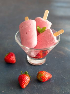 Koyu arkaplanda cam bir kasede yoğurdun üzerinde çilekli dondurma. Diyet, sağlıklı beslenme. Yaklaş, kopyalama alanı. Sıcak hava ve yaz için güzel yemekler..
