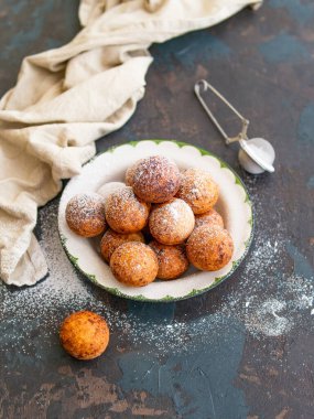 Güzel kahvaltı. Koyu arkaplanda şeker tozu olan süzme peynirli çörek topları. Kapatın. Boşluğu kopyala