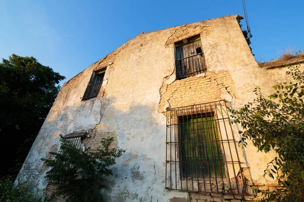 Casa envelhecida abandonada com janelas e grelhas fechadas . — Fotografia de Stock