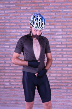 Genç bisikletçi giyinip aşağı bakıyor.