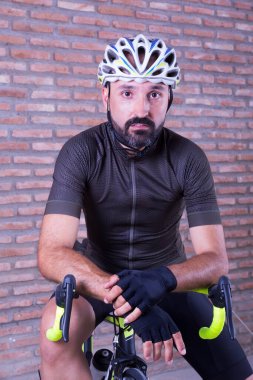 Genç bisikletçi dinlenirken kameraya bakıyor.