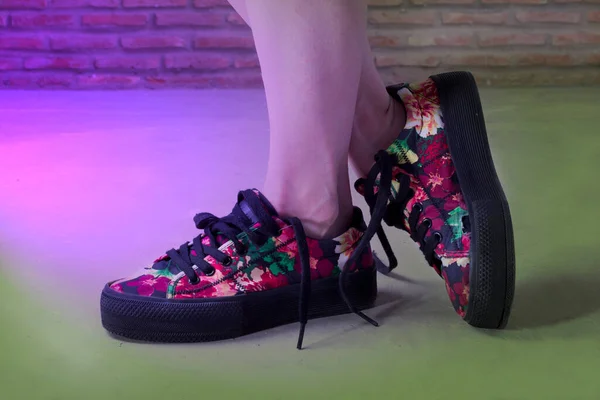 Mor ışıkla aydınlatılmış, eski görünümlü çiçekli ayakkabılar.