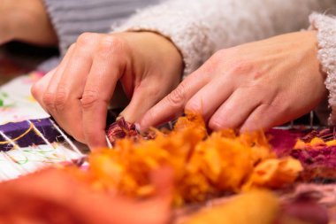 Yuvarlak dokuma tezgahında örgü ören kadın ellerine yakın çekim.