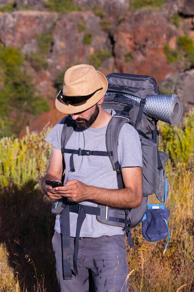 Латиноамериканец в солнечных очках проверяет свой смартфон