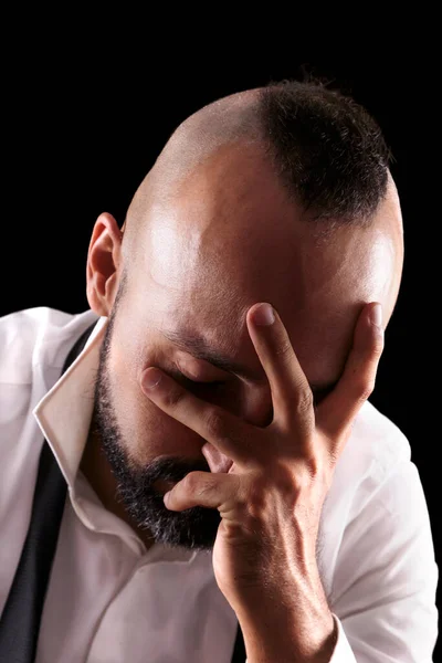 Gözü kapalı ağlayan depresif beyaz bir erkeğin yakın plan portresi.
