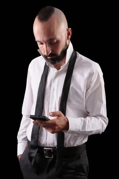 Knappe Spaanse man die zijn telefoon checkt terwijl hij zich aankleedt — Stockfoto
