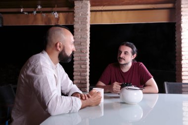 Dost canlısı genç erkekler çay içip kaynaşıyorlar.