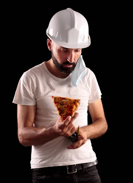 Genç İspanyol inşaat işçisi pizza yemeye çalışıyor.
