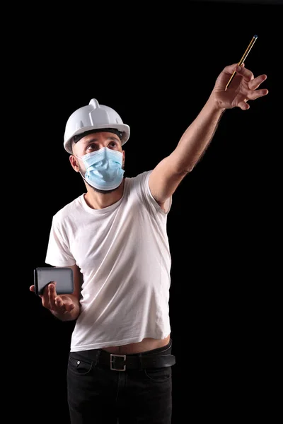 Young hispanic male construction worker with mask measuring angles — Stock Photo, Image