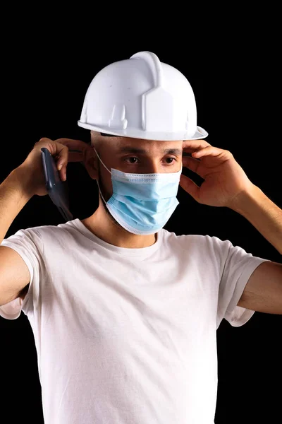 Young hispanic male construction worker putting on a mask Royalty Free Stock Images