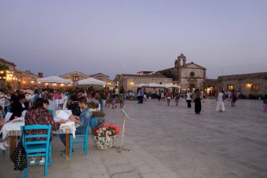 Marzamemi, İtalya - 1 Temmuz 2018 - eski balıkçı köyü İtalya'nın en güzel 20 deniz şehirlerinden biridir. Dünyanın her yerinden turist; Balık Restoran, lezzetli yemek tarifleri ve bu ortaçağ County düğün.