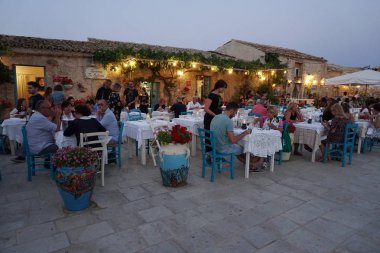 Marzamemi, İtalya - 1 Temmuz 2018 - eski balıkçı köyü İtalya'nın en güzel 20 deniz şehirlerinden biridir. Dünyanın her yerinden turist; Balık Restoran, lezzetli yemek tarifleri ve bu ortaçağ County düğün.