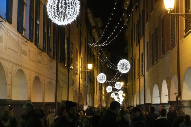 Chiavari, İtalya - 23 Aralık 2018 - tarihi Ortaçağ kenti Noel için insanlarla dolu. Kale ve sokağın ışıkları ve süs eşyaları ile. Dükkan arcade altında 
