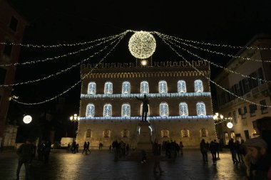 Chiavari, İtalya - 23 Aralık 2018 - tarihi Ortaçağ kenti Noel için insanlarla dolu. Kale ve sokağın ışıkları ve süs eşyaları ile. Dükkan arcade altında 