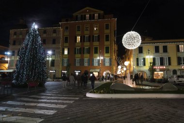Chiavari, İtalya - 23 Aralık 2018 - tarihi Ortaçağ kenti Noel için insanlarla dolu. Kale ve sokağın ışıkları ve süs eşyaları ile. Dükkan arcade altında 