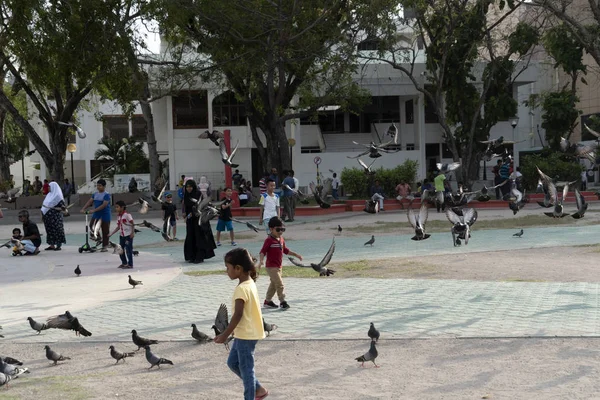 HOMBRES, MALDIVOS - 16 DE FEBRERO DE 2019 - Las personas y los niños en el lugar principal de la isla antes de la hora de rezar por la noche —  Fotos de Stock