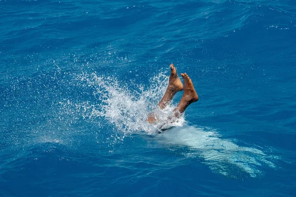 Мальдивский мужчина ныряющий с лодки в голубом океане — стоковое фото