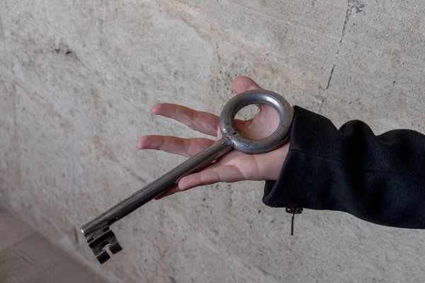Χέρι κρατώντας το γιγάντιο σίδερο μεσαιωνικό κλειδί — Φωτογραφία Αρχείου