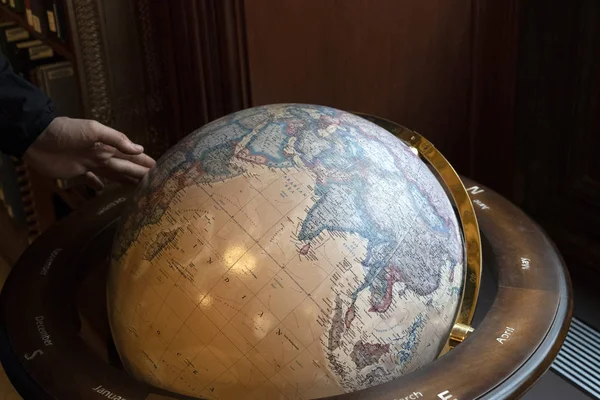 Hand touching earth globe
