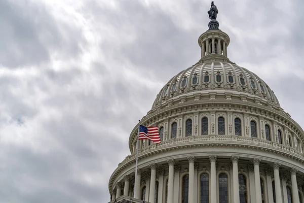 Washington DC Capitol with waving flag on sky background — Stock Photo, Image