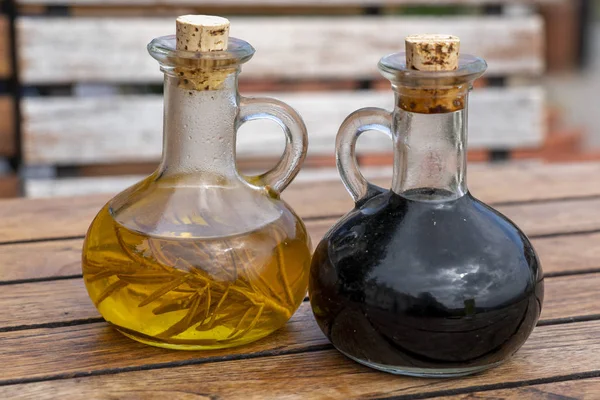 Oil and vinegar on wooden table — Stock Photo, Image