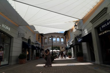 SERRAVALLE SİVİYA, İTALYA - 12 Temmuz 2020 - Tasarımcı satış sezonunun başında pek çok insan kapalı gişe maskesini takarak moda ürünleri satın alıyor