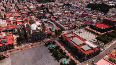 Toluca, Meksika merkezinin hava fotoğraflarında Plaza de los Mrwheels üzerinde uçarken Katedral, Belediye Binası, Plaza Gonzales Arratia 2 gibi birçok sembolik alan görebilirsiniz.