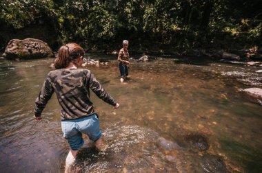 Anne ve kızı sıcak bir yaz gününde nehirde eğleniyor ve serinliyor..