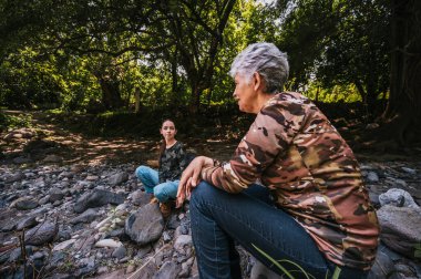Anne ve kızı bir süre dinlenip nehir kenarında konuşuyorlar..
