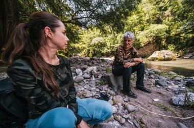 Anne ve kızı bir süre dinlenip nehir kenarında konuşuyorlar..