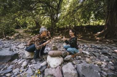 Anne ve kızı yeni yapılmış apachetalarının yanında fotoğraf çekiyorlar. Nehrin kenarında, gülümsüyorlar ve anın tadını çıkarıyorlar..