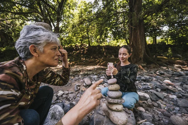 Anne ve kızı yeni yapılmış apachetalarının yanında fotoğraf çekiyorlar. Nehrin kenarında, gülümsüyorlar ve anın tadını çıkarıyorlar..