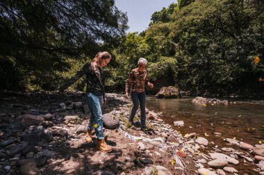 Anne ve kızı nehrin kıyısında yürürken eğleniyorlar. Aralarında bir sürü sarı kelebek uçuşuyor..