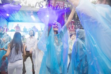 Amsterdam, Hollanda - 29 Temmuz 2017: Westerpark'taki Milkshake Festivali'nde yağmur ponçolarıyla yağmur altında dans eden insanlar