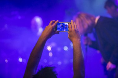 Amsterdam, Hollanda - 17 Şubat 2018 : Paradiso Noord - De Tolhuistuin'de İngiliz rock grubu The Charlatans'ın konserinde telefonuyla fotoğraf çeken seyirciler in kolları