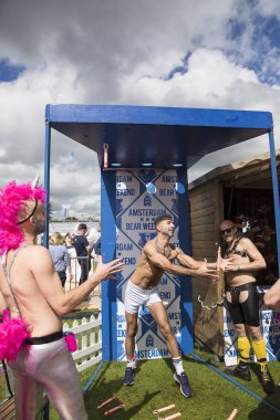 Amsterdam, Hollanda - 30 Temmuz 2017: Westerpark'taki Milkshake Festivali'nde düşen penisi yakalaması gereken bir oyunu oynarken eğlenen adam