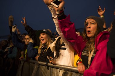 Traena, Norveç - 9 Temmuz 2015: Norveçli rock grubu Onklp & De Fjerne Slektningene'nin Traenafestival'deki konserinde silahla tezahürat taslayan hayranlar, traena adasında düzenlenen müzik festivali