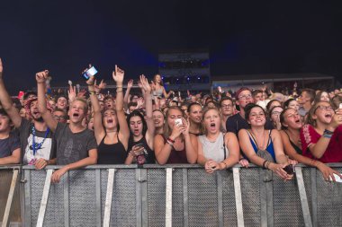 Nyon, İsviçre - 18 Temmuz 2017: Paleo Festivali'nde Fransız elektronik müzisyeni Petit Biscuit'in konserinde genç hayranların dinleyicileri