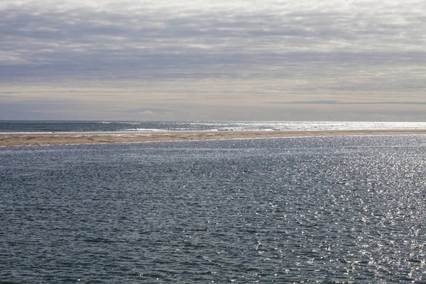 maritime seaside landscape with water, sand bank and white cloud, garonne estuary near Royan, France